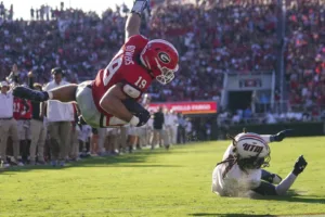 Georgia’s Brock Bowers dives over Tennessee-Martin safety Oshae Baker to score a touchdown in week one of the 2023 season. Bowers and the Georgia Bulldogs host South Carolina on Saturday at 2:30 on CBS. (Photo by JOHN BAZEMORE – COURTESY OF THE ASSOCIATED PRESS)