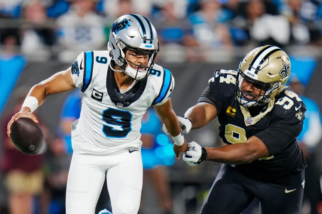 Carolina quarterback Bryce Young (9) is harassed by New Orleans Saints defensive end Cam Jordan (94) last Monday. Young sprained an ankle in the game and has been ruled out for this Sunday's game at Seattle. Also ruled out: Indy quarterback Anthony Richardson (concussion) for the Colts' game at Baltimore. (Photo courtesy of YAHOO! SPORTS)