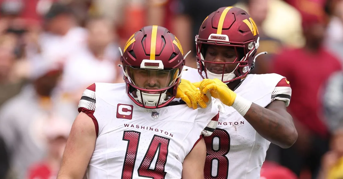 Washington quarterback Sam Howell gets a shoulderpad adjustment from teammate Brian Robinson during the game against the Arizona Cardinals on Sunday at FedEx Field. The Commanders held off the Cardinals, 20-16. (Photo courtesy of SCOTT TAETSCH – GETTY IMAGES)