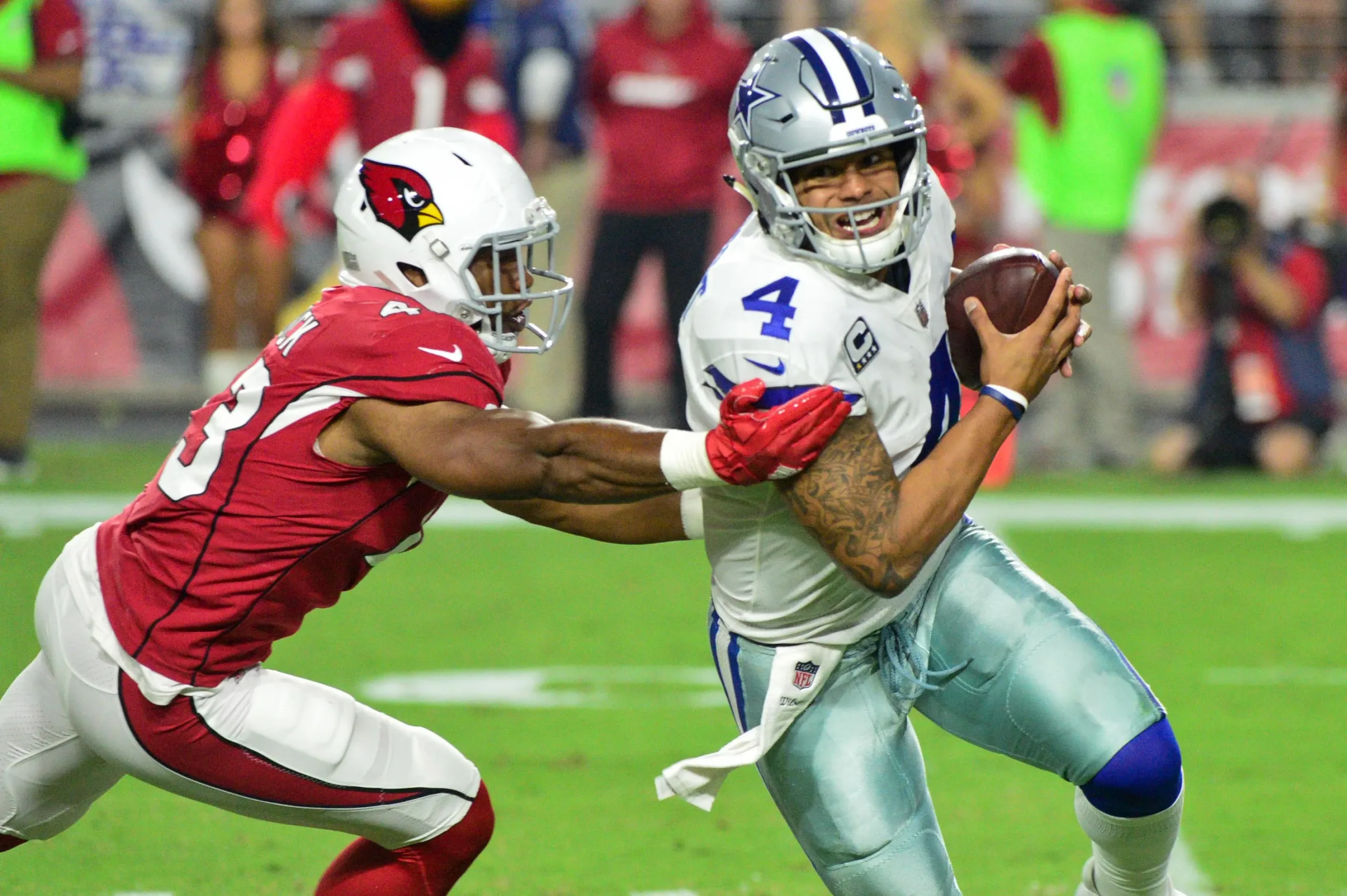 Dallas Cowboys quarterback Dak Prescott (right) tries to avoid Arizona linebacker Jesse Luketa. Prescott and the Cowboys couldn't avoid the upset Sunday, though, as the Cardinals got their first win of the season, a 28-16 victory over Dallas. (Photo courtesy of USA TODAY)