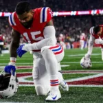 New England Patriots running back Ezekiel Elliott kneels in prayer before a recent game. Elliott's former team, the Dallas Cowboys, plan to honor him before Sunday's game at AT&T Stadium in Arlington. (Photo courtesy of CBSSPORTS.COM)