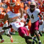 Clemson's Will Shipley (1) tries to vault Florida State linebacker Kevin Knowles. Florida State won the ACC showdown, beating the Tigers, 31-24 in overtime (Photo courtesy WRBL.COM)