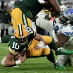 Green Bay Packers quarterback Jordan Love (10) is shown being sacked by Detroit Lions defensive tackle Alim McNeill (right) during the first half Thursday night at Lambeau Field in Green Bay, Wis. Lions running back David Mongtomery scored three touchdowns and Detroit had 211 rushing yards to take a 34-20 win. (Photo courtesy of THE ASSOCIATED PRESS)