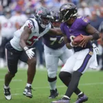 Baltimore quarterback Lamar Jackson (right) is sacked by Houston Texans pass rusher Will Anderson during the season opener between the teams in Baltimore on Sunday. The Ravens won the game, though, 25-9. (Photo courtesy of USATODAY.COM)