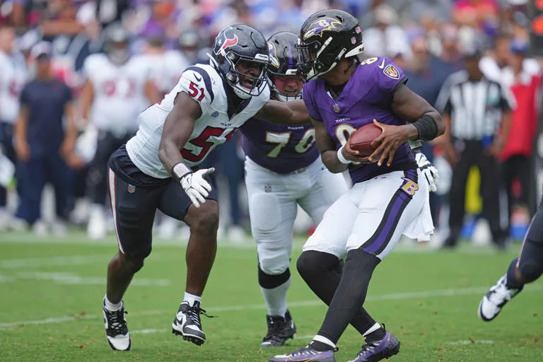 Baltimore quarterback Lamar Jackson (right) is sacked by Houston Texans pass rusher Will Anderson during the season opener between the teams in Baltimore on Sunday. The Ravens won the game, though, 25-9. (Photo courtesy of USATODAY.COM)