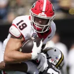Georgia tight end Brock Bowers (top) is hit by Vanderbilt defender Jaylen Mahoney during the Bulldogs' 37-20 win last Saturday. Bowers had surgery Monday for a high ankle sprain (his left ankle) and could miss up to six weeks. (Photo by GEORGE WALKER IV - Courtesy of THE ASSOCIATED PRESS).