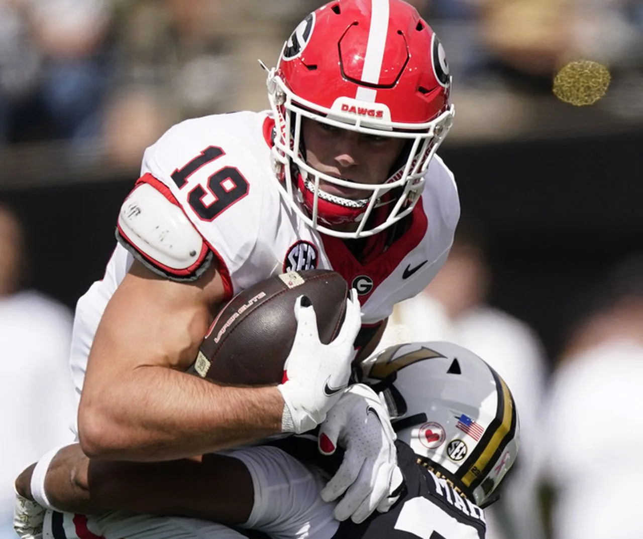 Georgia tight end Brock Bowers (top) is hit by Vanderbilt defender Jaylen Mahoney during the Bulldogs' 37-20 win last Saturday. Bowers had surgery Monday for a high ankle sprain (his left ankle) and could miss up to six weeks. (Photo by GEORGE WALKER IV - Courtesy of THE ASSOCIATED PRESS).