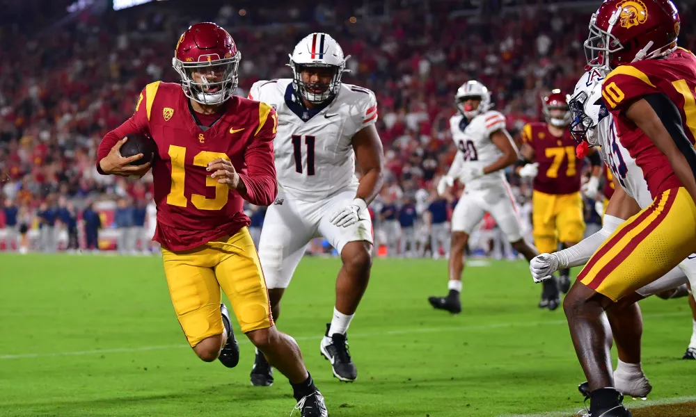 Southern Cal quarterback Caleb WIlliams (left) outran Arizona defenders to the end zone for a two-point conversion here, to escape an upset bid by the Wildcats. Southern Cal won in triple overtime, 43-41. (Photo courtesy of USATODAY.COM)