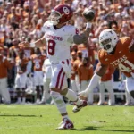 Oklahoma quarterback Dillon Gabriel (left) avoids the rush of Texas linebacker Jaylan Ford. OU scored late to top the Longhorns, 34-30. (Photo by JEFFREY McWHORTER - COURTESY OF THE ASSOCIATED PRESS)