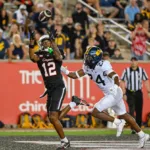 Houston's Stephon Johnson (left) hauls in a pass from Donovan Smith as time expires, topping West Virginia, 41-39, on Thursday night in Houston. (Photo by KEN MURRAY / Icon Sportswire, courtesy of GETTY IMAGES).