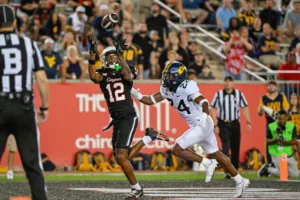 Houston's Stephon Johnson (left) hauls in a pass from Donovan Smith as time expires, topping West Virginia, 41-39, on Thursday night in Houston. (Photo by KEN MURRAY / Icon Sportswire, courtesy of GETTY IMAGES).