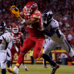 Kansas City tight end Travis Kelce (foreground) hauls in a catch, as Denver's Patrick Surtain (right) tries to bring him down. Kelce and the Chiefs held off Denver, 19-8, Thursday night. (Photo by ED ZURGA - Courtesy of THE ASSOCIATED PRESS)