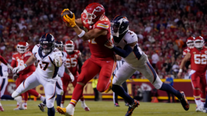 Kansas City tight end Travis Kelce (foreground) hauls in a catch, as Denver's Patrick Surtain (right) tries to bring him down. Kelce and the Chiefs held off Denver, 19-8, Thursday night. (Photo by ED ZURGA - Courtesy of THE ASSOCIATED PRESS)