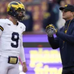 Michigan quarterback J.J. McCarthy (left) listens to coach Jim Harbaugh on the sidelines. The Wolverines are still number two in both the Associated Press and USA Today / AFCA Coaches polls that were released on Sunday. (Photo courtesy of MLIVE.COM)