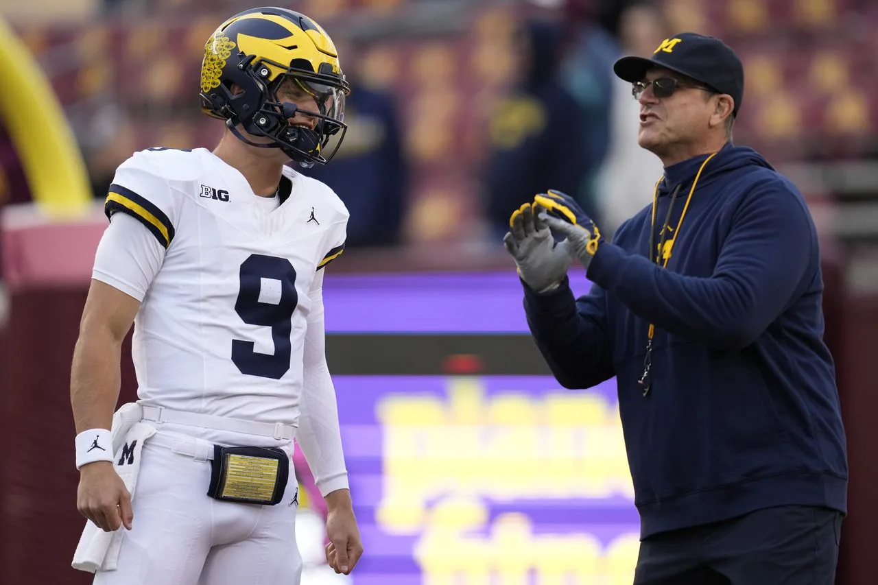 Michigan quarterback J.J. McCarthy (left) listens to coach Jim Harbaugh on the sidelines. The Wolverines are still number two in both the Associated Press and USA Today / AFCA Coaches polls that were released on Sunday. (Photo courtesy of MLIVE.COM)