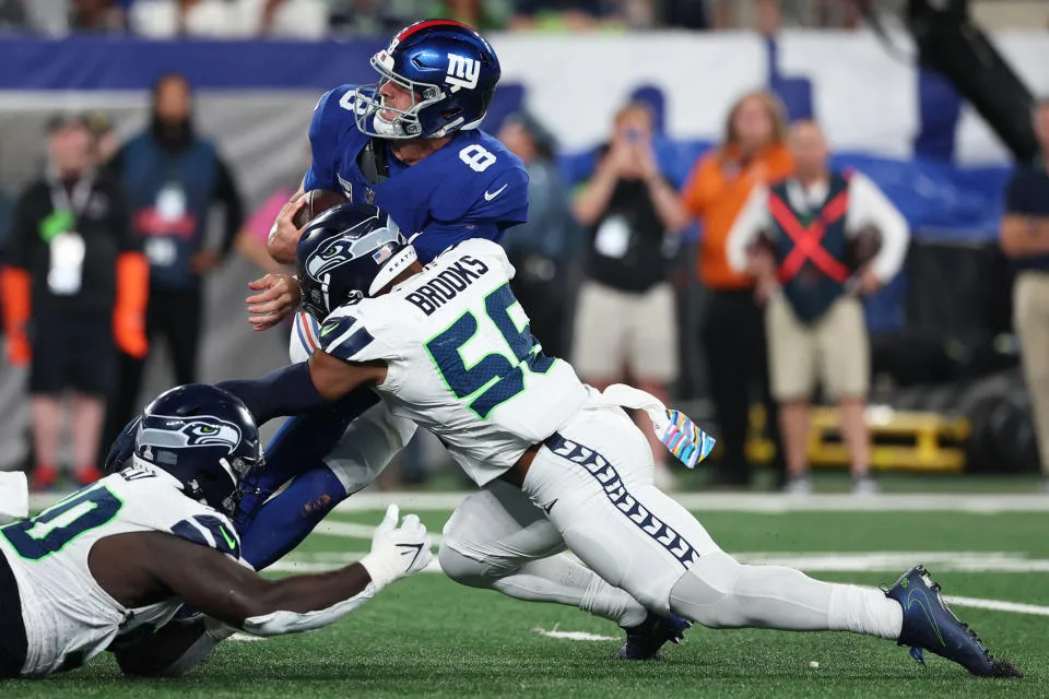 New York Giants quarterback Daniel Jones (top, 8) is sandwiched between two Seattle Seahawks defenders in the Seahawks' 24-3 rout of the Giants on Monday night at MetLife Stadium in New Jersey. (Photo courtesy of SPORTS.YAHOO.COM)