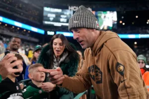 New York Jets quarterback Aaron Rodgers (right) interacts with a group of fans in Las Vegas, before the Jets' game against the Raiders on Sunday night. The Jets lost to the Raiders, 16-12. It's been speculated that Rodgers could return before the end of the season; in fact, NBC's Melissa Stark's speculation was called into question by Rodgers on Tuesday's episode of "The Pat McAfee Show." (Photo courtesy of CITIZENSIDED.COM)