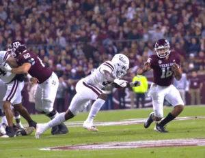 Texas A&M quarterback Jaylen Henderson (16, right) tries to escape a Mississippi State defender. A&M beat MSU, 51-10, on Saturday, and then both head coaches were dismissed within 36 hours of the game. TFB editor/publisher Mitch Lucas speculates what direction the Aggies are headed with their head coaching position. (Photo by ALEX NABOR - THE FOOTBALL BEAT)