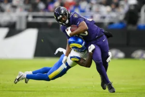 Tylan Wallace (right) escapes an attempted tackle and goes 76 yards to help the Baltimore Ravens beat the Los Angeles Rams, 37-31, in overtime on Sunday. (Photo courtesy of U.S. NEWS)