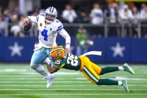 The Green Bay Packers harassed Dallas Cowboys quarterback Dak Prescott (left), who threw for 403 yards and three touchdowns, but also had two interceptions that led to Packers' scores in Green Bay's 48-32 upset win at AT&T Stadium on Sunday. (Photo courtesy of YAHOOSPORTS.COM)