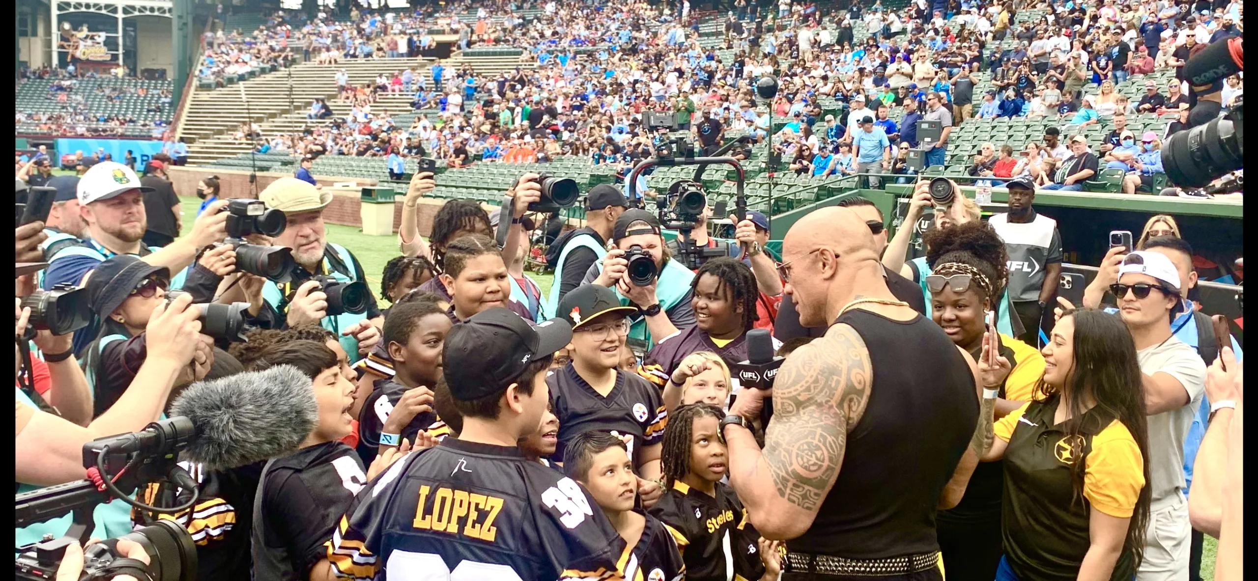 Dwayne "The Rock" Johnson talks to an Arlington-area football team prior to kickoff of the Arlington Renegades-Birmingham Stallions game at Choctaw Stadium, the first-ever game under the UFL banner. (Photo by MITCH LUCAS)