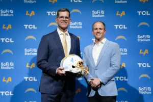 The Los Angeles Chargers introduced Jim Harbaugh (left) as head coach on Feb. 1; Harbaugh posed with John Spanos, head of business operations, for this photo. The Chargers are a team wanting very much to trade out of the No. 5 pick in next week's NFL Draft. (Photo by ASHLEY LANDIS / Courtesy of THE ASSOCIATED PRESS)