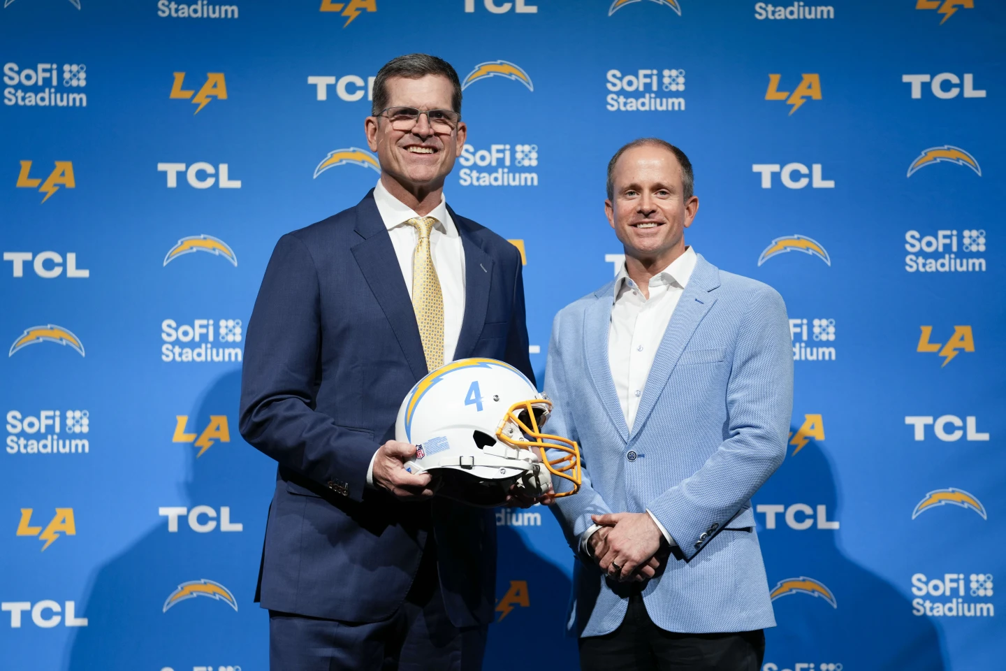 The Los Angeles Chargers introduced Jim Harbaugh (left) as head coach on Feb. 1; Harbaugh posed with John Spanos, head of business operations, for this photo. The Chargers are a team wanting very much to trade out of the No. 5 pick in next week's NFL Draft. (Photo by ASHLEY LANDIS / Courtesy of THE ASSOCIATED PRESS)