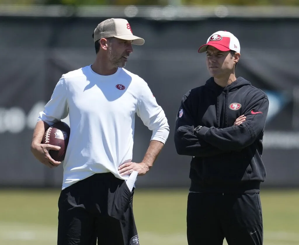 New San Francisco 49ers defensive assistant Brandon Staley (right), a former L.A. Chargers head coach, listens as Niners coach Kyle Shanahan talks during a practice on Thursday. Staley has rebooted his career after being dismissed by the Chargers last season before its completion. (Photo by JEFF CHIU, courtesy of THE ASSOCIATED PRESS)