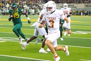 Texas quarterback Quinn Ewers (foreground) scrambles against Baylor. Ewers and the Longhorns will compete for the first time in the Southeastern Conference this season, and actually visit defending national champion Michigan the second week of the season. (Photo by DENNIS JACOBS - THE FOOTBALL BEAT)