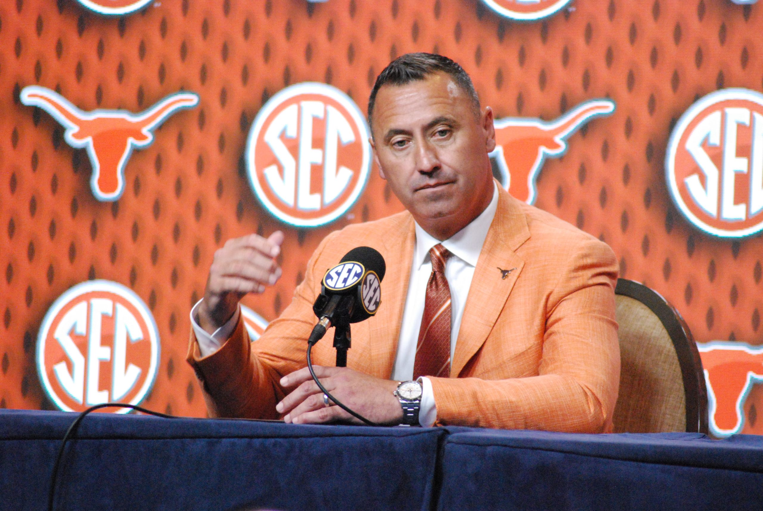 Texas coach Steve Sarkisian, who guided the Longhorns to their first-ever trip to the College Football Playoff a year ago, ponders a question at SEC Media Days in Dallas in July. Sarkisian and the 'Horns play at Michigan this Saturday at 11 a.m. on FOX. (Photo by VIRGINIA HAGLER-LUCAS - THE FOOTBALL BEAT)